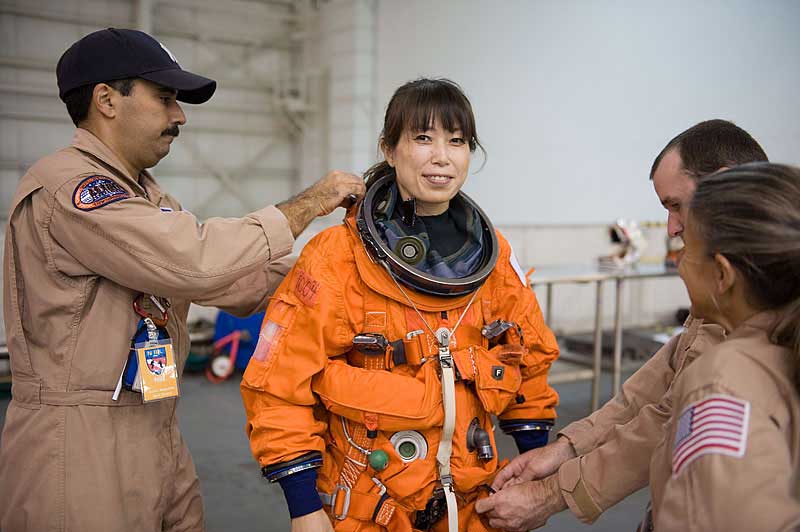 Naoko Yamazaki gets help in the donning of her shuttle launch and entry suit in preparation for a water survival training session...
17 Sept. 2009 --- Japan Aerospace Exploration Agency (JAXA) astronaut Naoko Yamazaki, STS-131 mission specialist, gets help in the donning of her shuttle launch and entry suit in preparation for a water survival training session in the Neutral Buoyancy Laboratory (NBL) near NASA's Johnson Space Center. United Space Alliance suit technicians assisted Yamazaki.
