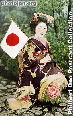 Patriotic Maiko. Card designed to encourage soldiers on the front line. Notice that her sleeves are so long that you can see her right sleeve touch the ground. That's the kimono of a maiko. This is a modern postcard reproduction.
Keywords: japanese vintage postcards nihon bijin women beauty geisha maiko woman kimono flag