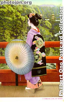 Maiko with umbrella. The quickest way to tell if she is a geisha or maiko is by looking at her back. The tell-tale sign of a maiko is her long obi sash hanging down behind. Whereas the geisha's sash has a short knot instead.
Keywords: japanese vintage postcards nihon bijin women beauty geisha maiko woman kimono umbrella kyoto