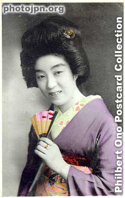 Smiling for the camera. It's always nice to see a smiling woman on a vintage postard. This is not an ideal smile though. Kind of sheepish and unnatural. Sort of half-hearted and "halfway" like her fan which is only half open.
Keywords: japanese vintage postcards nihon bijin women beauty kimono