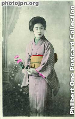 Woman with flowers. She's wearing two rings on her left hand. She looks like a wife alright. How can you tell? Well, her kimono has a plain design, and the word "married" is written on her face.
Keywords: japanese vintage postcards nihon bijin women woman beauty kimono flowers