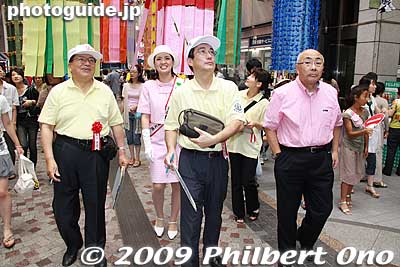 During the morning of Aug. 6 the first day, a team of judges wearing a white cap and yellow shirt proceed through the decorations for judging. Dressed in pink is the back is one of the three Sendai Goodwill Ambassadors (not Miss Tanabata).
Keywords: miyagi sendai tanabata matsuri festival tohoku star bamboo decorations