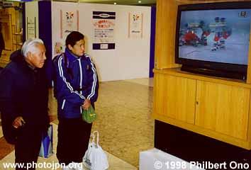 An elderly couple are among a crowd of people who watched the men's hockey finals on the TV set.
Keywords: nagano prefecture 1998 winter olympics