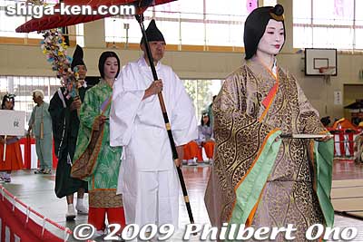 The woman on the right is the Onna Betto (or Nyo-betto) (女別当) who was the supervisor of the court ladies at special occasions such as the Saio procession. The lady behind her is another Nyoju court lady. And in the end is the Zoshiki (雑色) handym
Keywords: shiga koka tsuchiyama saio princess procession kimono women matsuri festival 