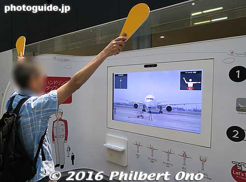 A visitor tries an interactive exhibit for directing a JAL plane to a gate.
Keywords: tokyo ota-ku haneda airport JAL maintenance facility planes boeing jets hangar tour museum