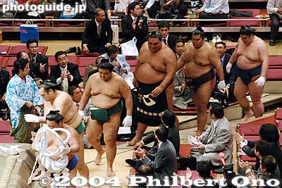 Musashimaru acknowledges a spectator as he proceeds to the ring.
This was a demonstration on how they tie on the thick, white rope (tsuna) around his waist. The tsuna is the symbol of the yokozuna. It takes several assistants to put it on. They are all wearing white gloves.
Keywords: tokyo ryogoku kokugikan sumo yokozuna musashimaru retirement