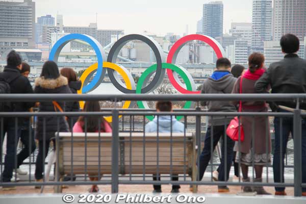 Tourists gaze at the Olympic rings in Odaiba