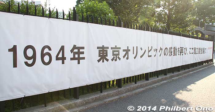 Sign on the fence of the old Japan National Stadium: Let's have the excitement of the 1964 Tokyo Olympics come again here at National Stadium!