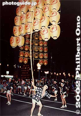 The objective is to balance the kanto steady enough so that the candles in the paper lanterns don't go out. 
The performer has to move about deftly whenever there is a gust of wind or when the pole starts to bend over. After attaining a steady balance, the skillful technician shifts the pole to other parts of his body while his surrounding colleagues clap and shout "Dokkoisho! Dokkoisho!"

Occasionally, someone loses his balance and the pole and lanterns come crashing down on the power lines, safety ropes, or right on the crowd. When I was there, one came crashing down on the crowd I was in. We all screamed. But it was surprisingly harmless. All the lanterns flamed out and some lanterns had holes. The lanterns were just relit and raised again. Falling kanto added real drama.
Keywords: akita kanto matsuri festival lantern
