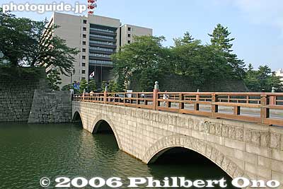 Bridge to castle grounds with prefectural capital building looming ahead.
Keywords: fukui castle moat stone wall