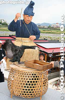 He took out one of the cormorants from the basket cage. In Japanese, the bird is called umi'u. They normally fish in the ocean as opposed to the kawa'u river cormorant which are smaller and have been devastating to the fish in Lake Biwa.
Keywords: gifu nagaragawa river ukai cormorant fishing fisherman birds boats