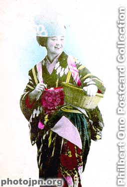 Laughing Geisha with Basket. It looks like she's dressed for picking tea leaves. This card, which has an undivided back, dates before 1907. The actual card is more yellowed.
Keywords: japanese vintage postcards nihon bijin women beauty geisha maiko woman smiling smile laughing kimono