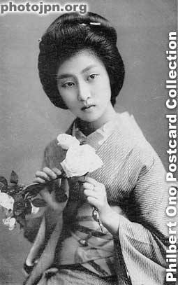 Woman with two flowers. She's holding the flowers in a cross or "X" mark. I wouldn't call that a good way to hold flowers (unless you're a hula dancer).
Keywords: japanese vintage postcards nihon bijin women woman beauty kimono flowers