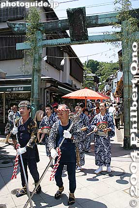 The festival is actually held from the first to second Sunday in July. Eighth day is the main day.
The festival procession comes toward Enoshima's gateway which is the Seido no Torii (青銅の鳥居) gate. 
This day-long festival starts at 9:30 am at Enoshima's Hetsunomiya Shrine. A large mikoshi (portable shrine) from Yasaka Shrine is carried from the shrine to Koyuguri Shrine on the mainland. Along the way, the mikoshi is carried into the ocean. On the mainland, the Yasaka mikoshi is met with a mikoshi from Koyuguri Shrine. They then parade together along a shopping street before the Yasaka mikoshi goes back to Enoshima at around 6 pm.
Keywords: kanagawa, enoshima, tenno-sai matsuri, festival
