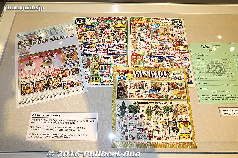 The table showcase displaying New Year's newspaper ads for Oshogatsu sales by Japanese supermarkets in Hawai’i.
