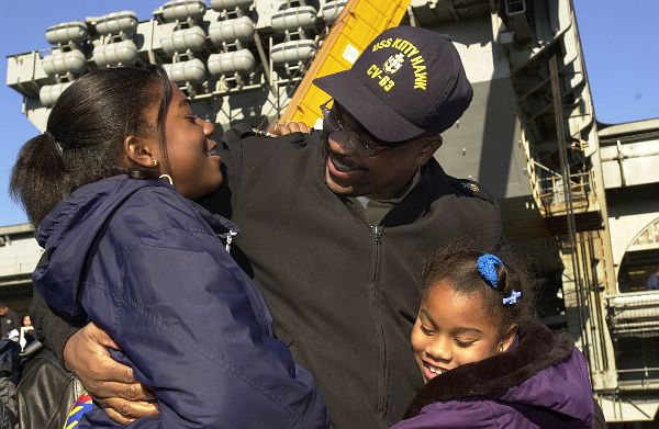 Yokosuka, Japan (December 23, 2001) -- Senior Chief Petty Officer Willie Harden is greeted by his two daughters after returning home aboard USS Kitty Hawk (CV 63).
Command Fleet Activities, Yokosuka, Japan (December 23, 2001) -- Senior Chief Petty Officer Willie Harden is greeted by his two daughters after returning home aboard USS Kitty Hawk (CV 63). Kitty Hawk and its embarked carrier air wing five (CVW-5) returned home following months of sustained bombing missions in support of Operation Enduring Freedom. U.S. Navy Photo by Photographer’s Mate 2nd Class Jennifer A. Smith (Released)
