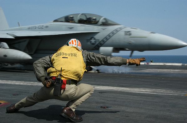 7th Fleet Area of Responsibility (AOR) Mar. 21, 2004 - An F/A-18F Super Hornet assigned to the “Diamondbacks” of Strike Fighter Squadron One Zero Two (VFA-102) launches past Lt. Cmdr. Mark W. Kekeisen, of St. Louis, Mo., as it speed its way down.
7th Fleet Area of Responsibility (AOR) Mar. 21, 2004 - An F/A-18F Super Hornet assigned to the “Diamondbacks” of Strike Fighter Squadron One Zero Two (VFA-102) launches past Lt. Cmdr. Mark W. Kekeisen, of St. Louis, Mo., as it shuttles its way down USS Kitty Hawk’s (CV 63) flight deck before becoming airborne. Kitty Hawk is currently underway in the 7th Fleet area of responsibility (AOR), and is the U.S. Navy’s only permanently forward-deployed aircraft carrier, operating from Yokosuka, Japan. U.S. Navy photo by Photographer’s Mate 3rd Class Jason T. Poplin. (RELEASED)
