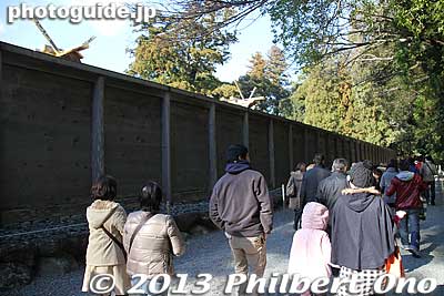 High walls prevent us from seeing the sacred shrine buildings of Naiku. Photography is not allowed inside these walls so don't try to use a long pole with a camera attached to take pictures. There are guards everywhere. 
Keywords: mie ise jingu japanshrine shinto hatsumode new year&#039;s day shogatsu worshippers