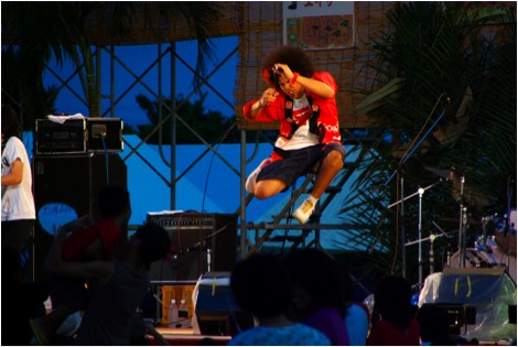 August:  The lively lead-singer of a popular band named Zukan jumps and shouts while performing at the Kin Festival.  During the summer months there are festivals every weekend, somewhere on the island.
Photo copyright 2009 Michael Lynch.
Keywords: okinawa seasons 