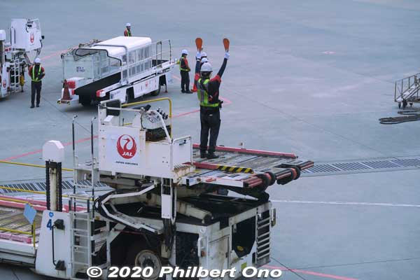 Ramp Marshall signaling a Japan Airlines Boeing 777-200 arriving at the gate at Naha.
Keywords: okinawa naha airport boeing plane