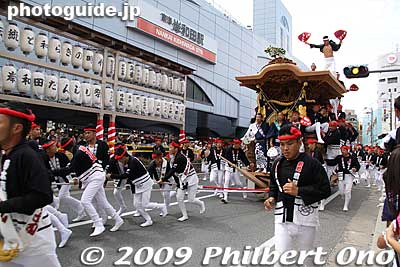 They run while pulling the danjiri floats while a man on the float's roof dances and prances with two fans. They pass by very quickly, unlike other float festivals. This is in front of Kishiwada Station.
Keywords: osaka kishiwada danjiri matsuri9 festival floats 