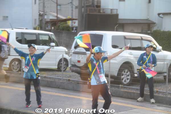 Volunteers on the street waving at buses.
Keywords: saitama Kumagaya Rugby World Cup stadium