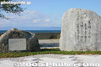 [color=blue][b]Verse 5 Song Monument, Hikone Port[/b][/color] 五番の歌碑。彦根港
The left stone is inscribed with the entire song, and bigger stone on the right has the lyrics for verse 5. There is also another stone which shows a map of the lake and rowing route. The monument is now encroached by tall grass and weeds.

This song monument was built in Oct. 2005 at a cost of 8 million yen (gathered through donations). With this, now all six verses each have a song monument. This one is next to Hikone Port where you board the boat to visit [url=http://photoguide.jp/pix/thumbnails.php?album=18] Chikubushima[/url] or [url=http://photoguide.jp/pix/thumbnails.php?album=145]Takeshima.[/url]
Keywords: shiga lake biwa rowing song biwako shuko no uta boating monument