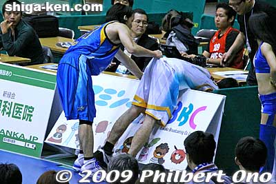 Joho helps up a Takamatsu player who crashed into a billboard.
Keywords: shiga hikone lakestars pro basketball game takamatsu five arrows 