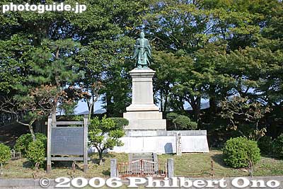 Statue of Ii Naosuke near the Hikone Castle moat. Lord of the castle and also an important historical figure. 井伊 直弼
Ii Naosuke was the Tokugawa shogunate's Chief Minister (Tairo) who favored and concluded commercial treaties with the Western powers and thus broke Japan's isolation from the world. Foreigners were then allowed to trade with Japan and take up residence in cities like Yokohama and Hakodate. Ii was later assassinated in 1860 by samurai radicals from Mito (Ibaraki) who sought to oust the foreign "barbarians." 
Keywords: shiga hikone castle