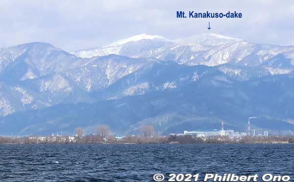Mt. Kanakuso-dake (金糞岳 or Azai-dake) behind Takatsuki in Nagahama. The peak to the left is Shirakura-dake (白倉岳). The orange/white smokestack is from the Nippon Electric Glass factory (日本電気硝子) in Takatsuki. 
Keywords: shiga nagahama port Lake Biwa biwako cruise boat biwakobest
