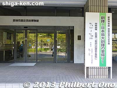Museum entrance with a sign indicating the Homecoming Exhibition for Japan’s Largest Bronze Bell to mark the museum's 25th anniversary.
Keywords: shiga yasu dotaku museum bronze bell