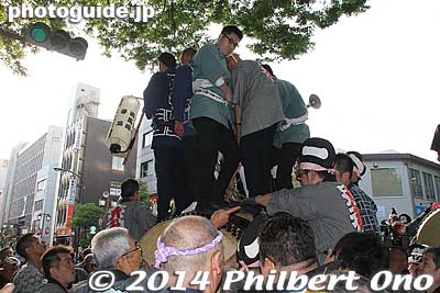 Men standing precariously on one of the smaller taiko drums. They hold on to a rope tied to the drum. The smallest taiko is 1.29 meter wide. Up to 11 people stand on it.
Keywords: tokyo fuchu kurayami matsuri festival floats taiko drummers