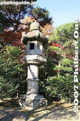 Many large stone lanterns are in the garden.
