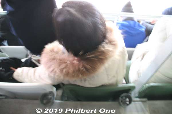 In front of me, this person's head was slightly above my knees when I was sitting. 
A little kid sitting can easily kick the person's head in front. The drink holder is also on the floor. 
Keywords: tokyo shinjuku olympic national stadium