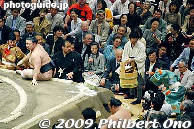 The referee is thrown into the crowd by the wrestler (by accident, of course). An attendant carries the water bucket out of the way so the referee does not crash into it and spill the water. A judge looks on concerned, while some spectators are amused.
Keywords: tokyo sumida-ku ward ryogoku kokugikan sumo tournament ozumo rikishi wrestlers japankokugikan